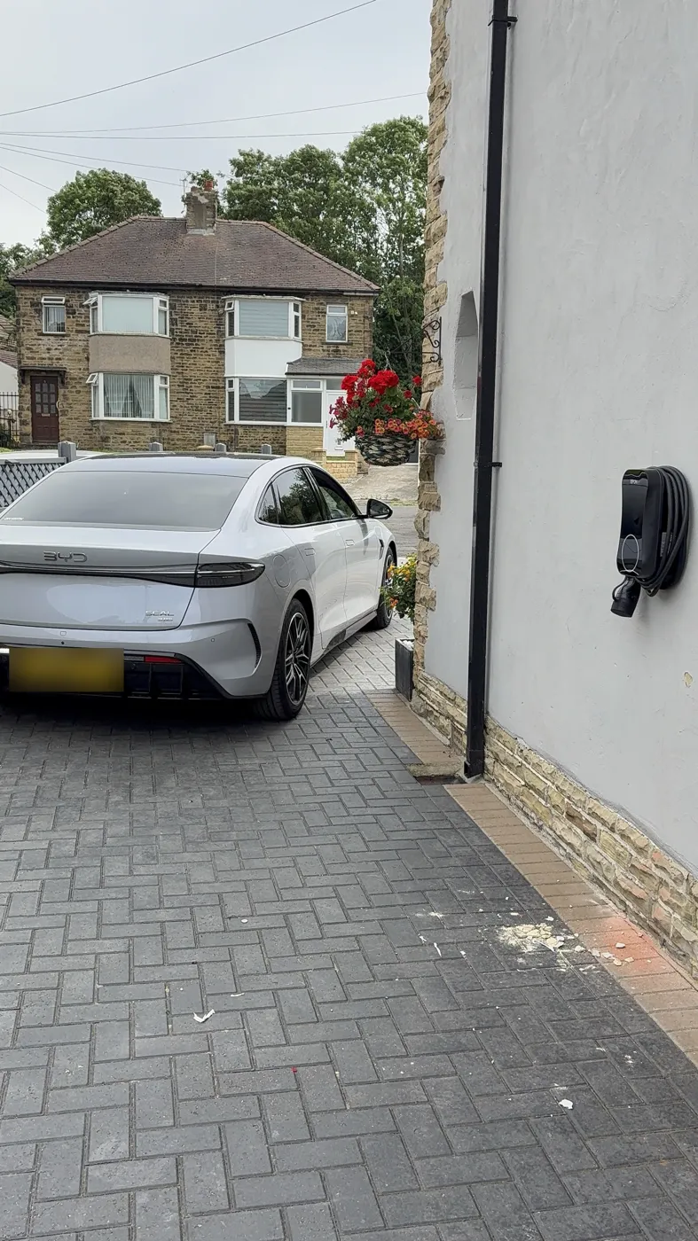 BYD Seal on a Bradford driveway beside a tethered RiponEV charger on a rendered wall