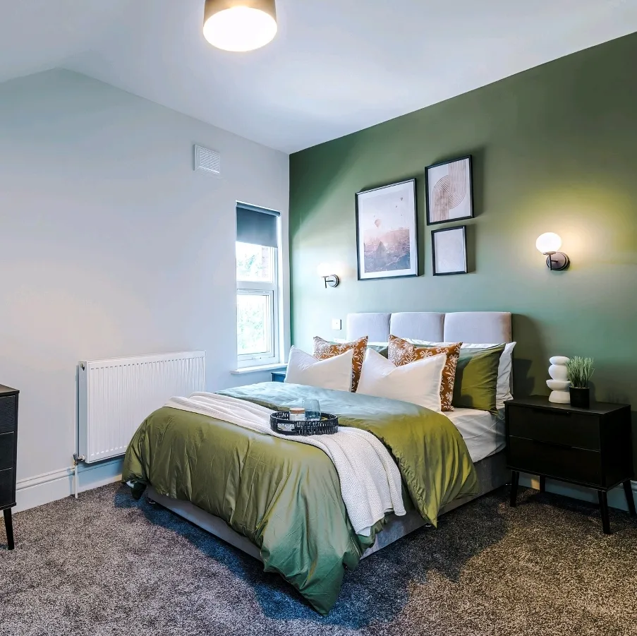Finished bedroom with twin wall lights either side of the bed and a ceiling light