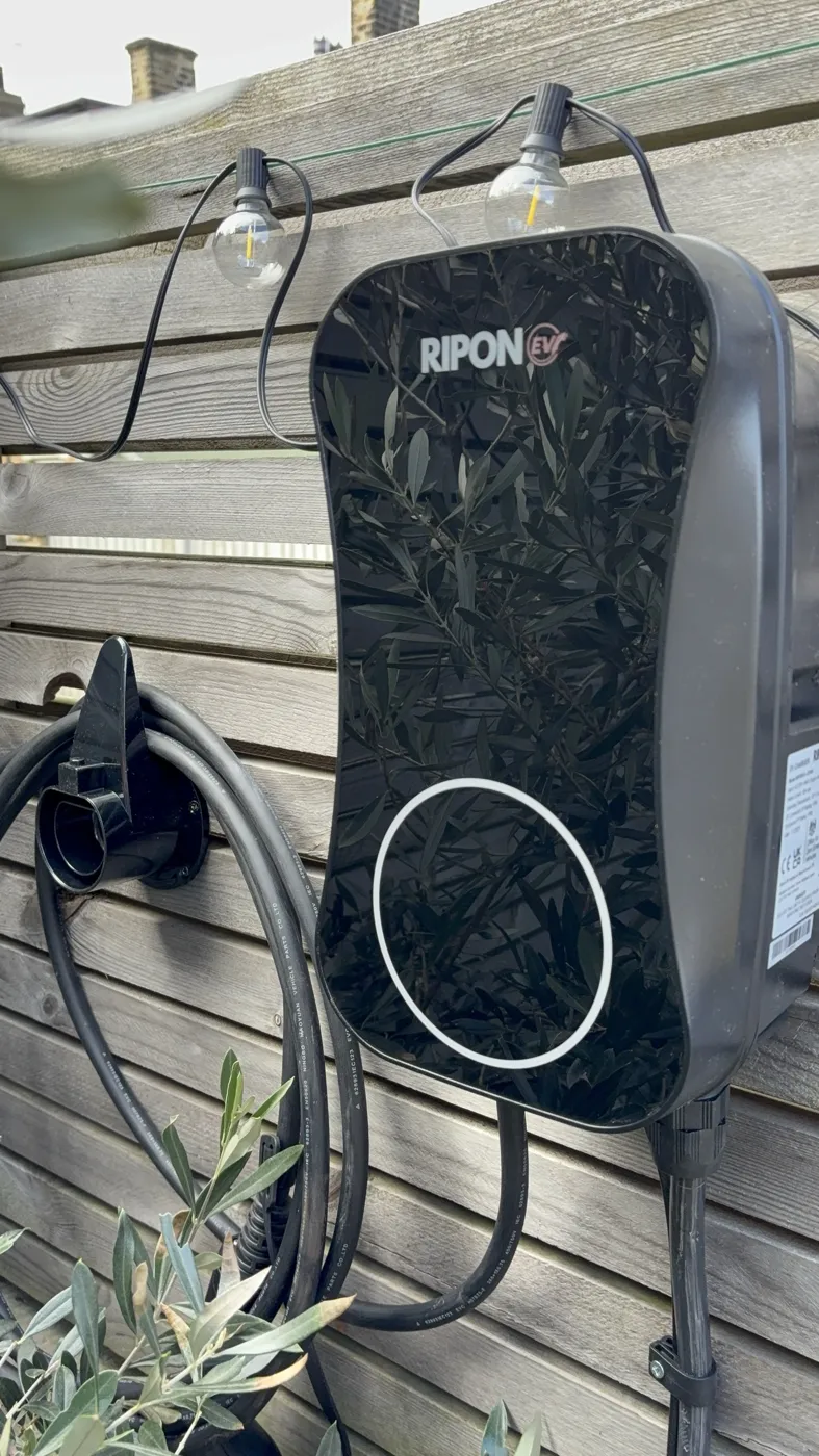 Tethered RiponEV charger on a timber slatted fence with a connector holster