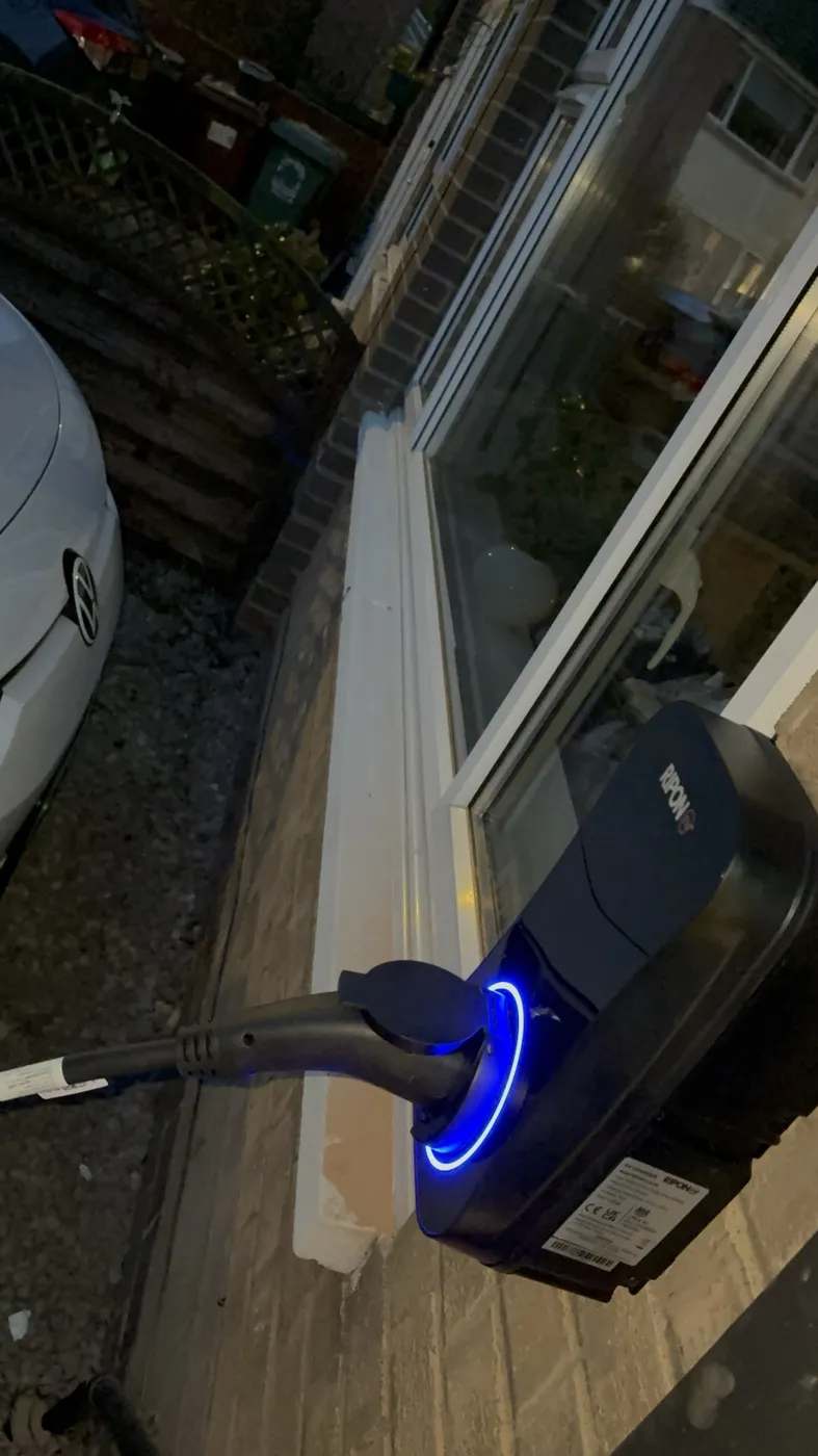 RiponEV charger charging a Volkswagen at night, blue ring lit