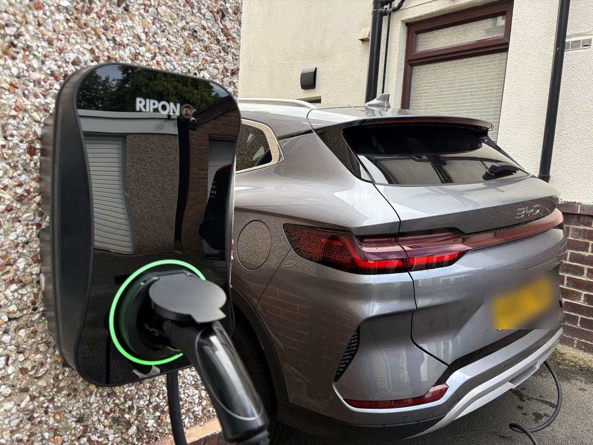 EV charger on a pebble-dash wall charging a BYD