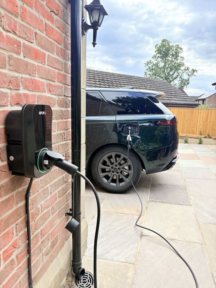 EV charger installed beside a patio, charging a Range Rover