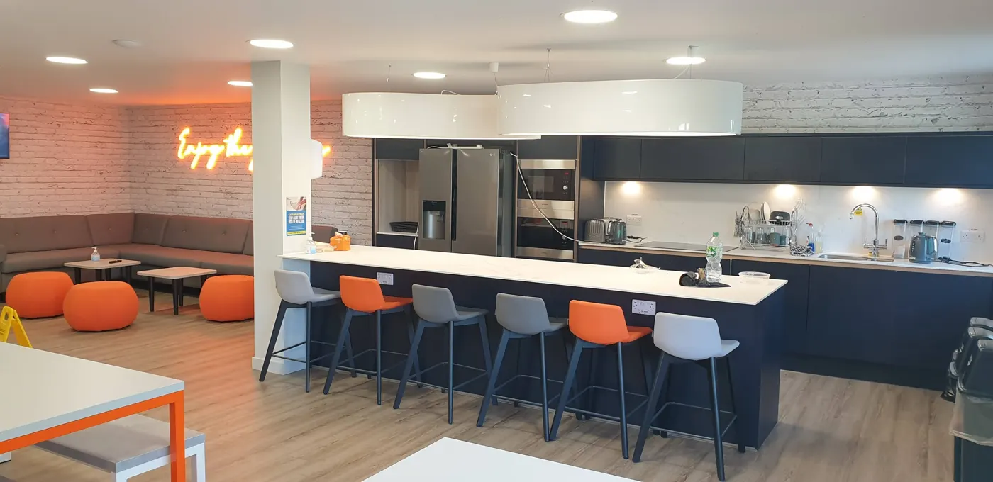 Office breakout kitchen with downlights and pendant lights