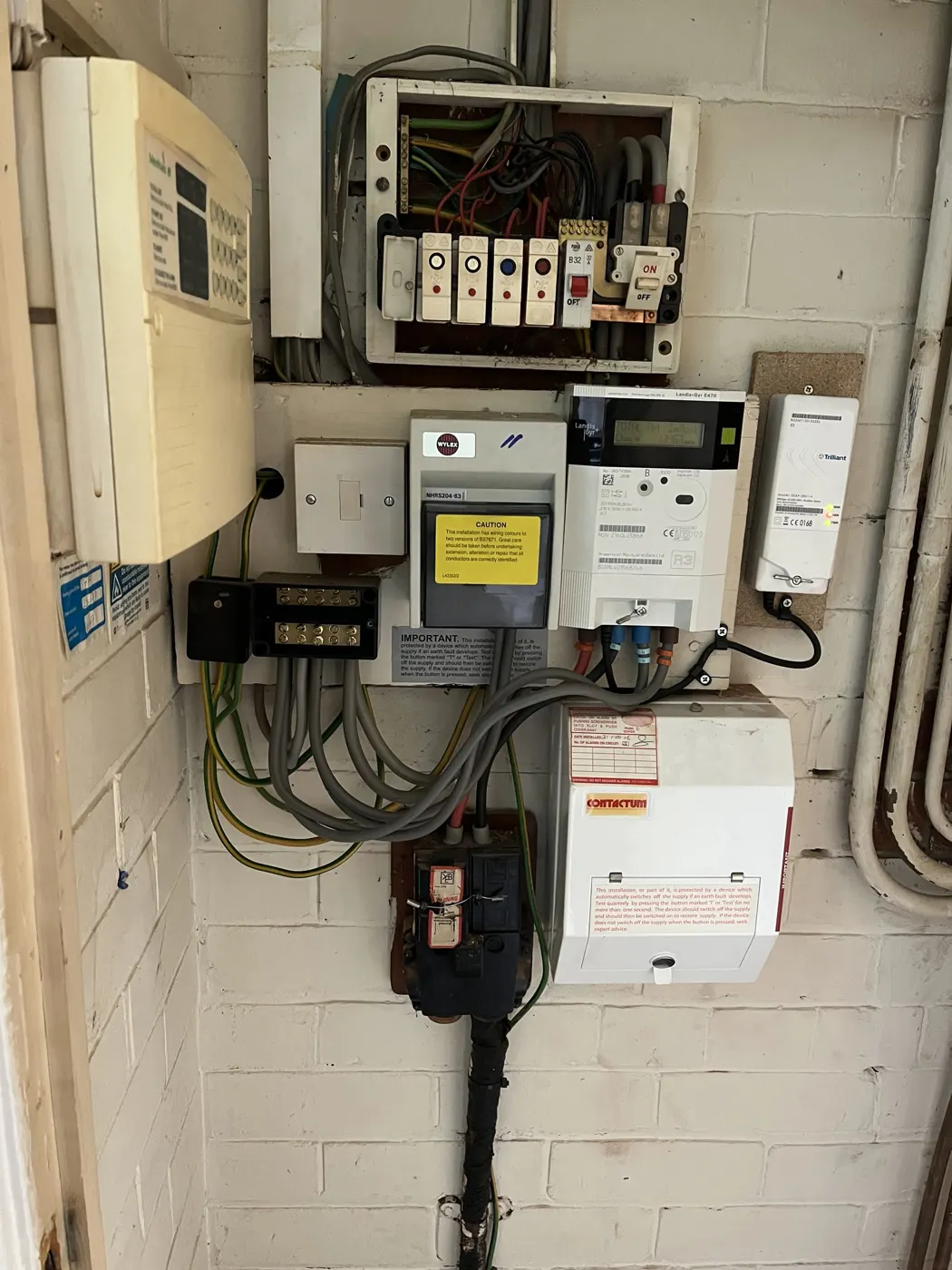 Old rewireable-fuse board and separate RCD unit beside the meter