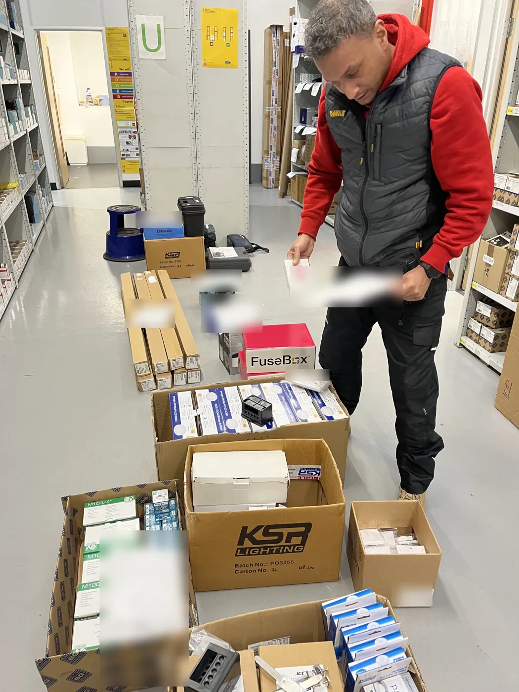 Commercial order of emergency bulkheads, LED battens, back boxes and a consumer unit being checked at the wholesaler