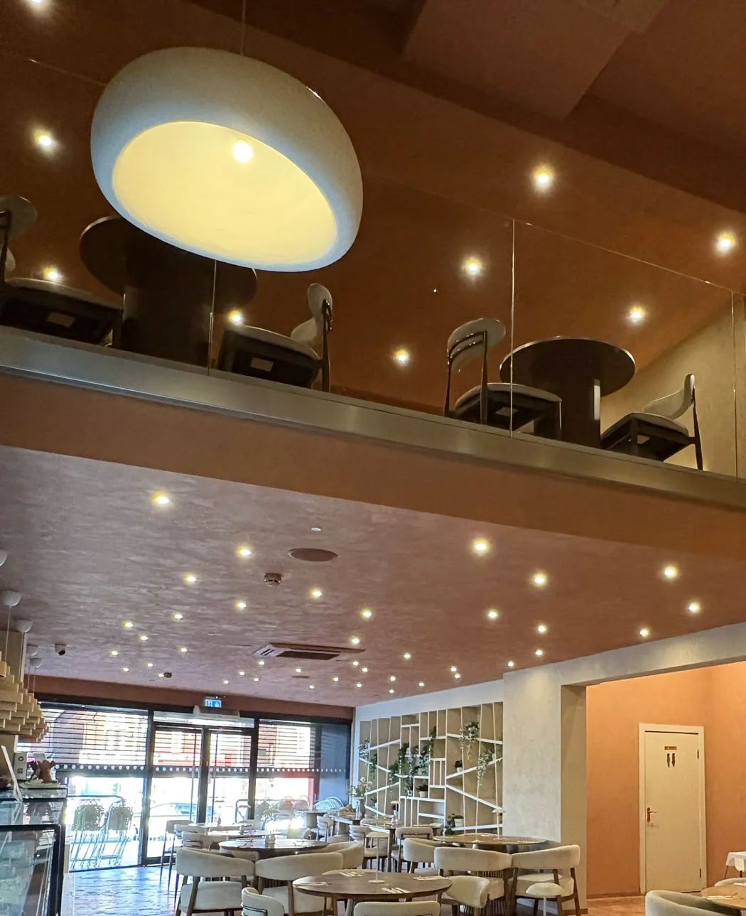 Restaurant fit-out with LED downlights under a mezzanine and large feature pendants