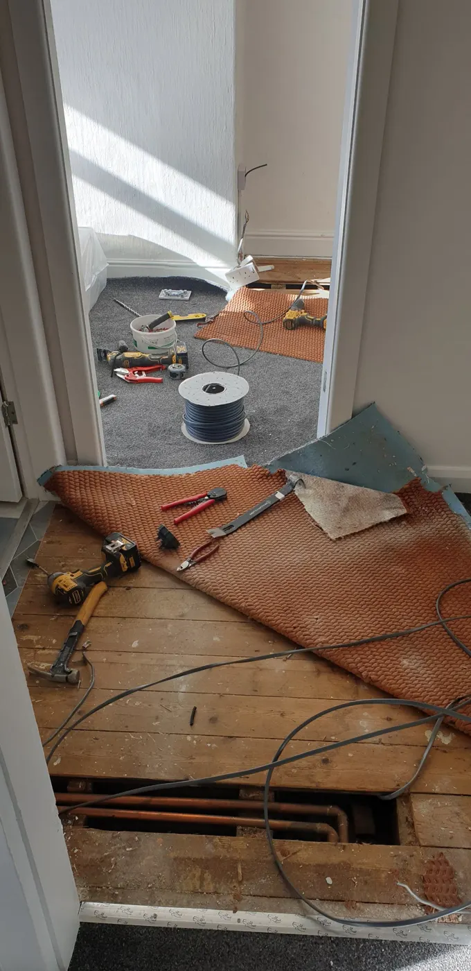 Floorboards lifted and carpet folded back to run new cables