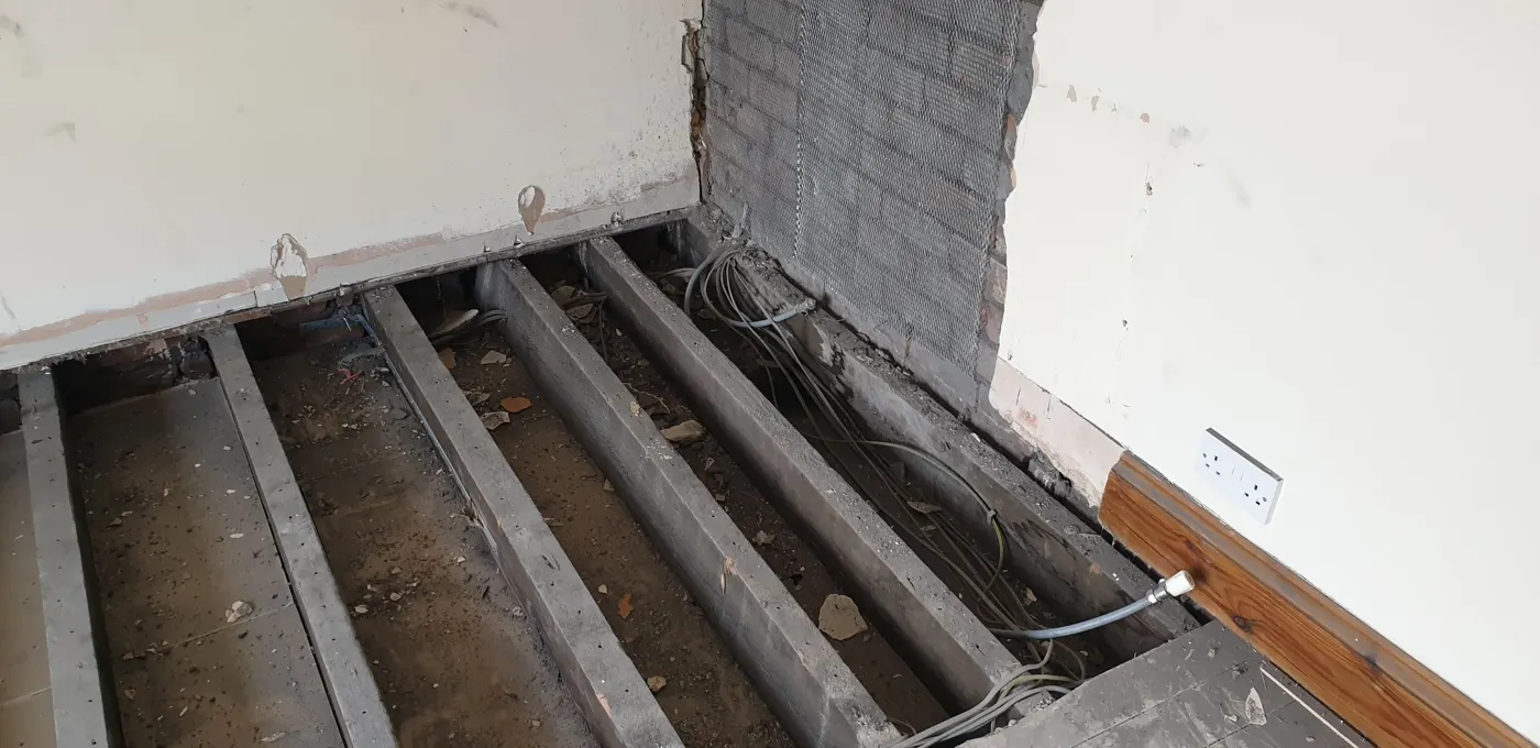 Old cables exposed under lifted floorboards before a rewire