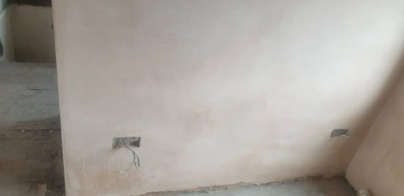 Freshly plastered wall with cables ready at back boxes