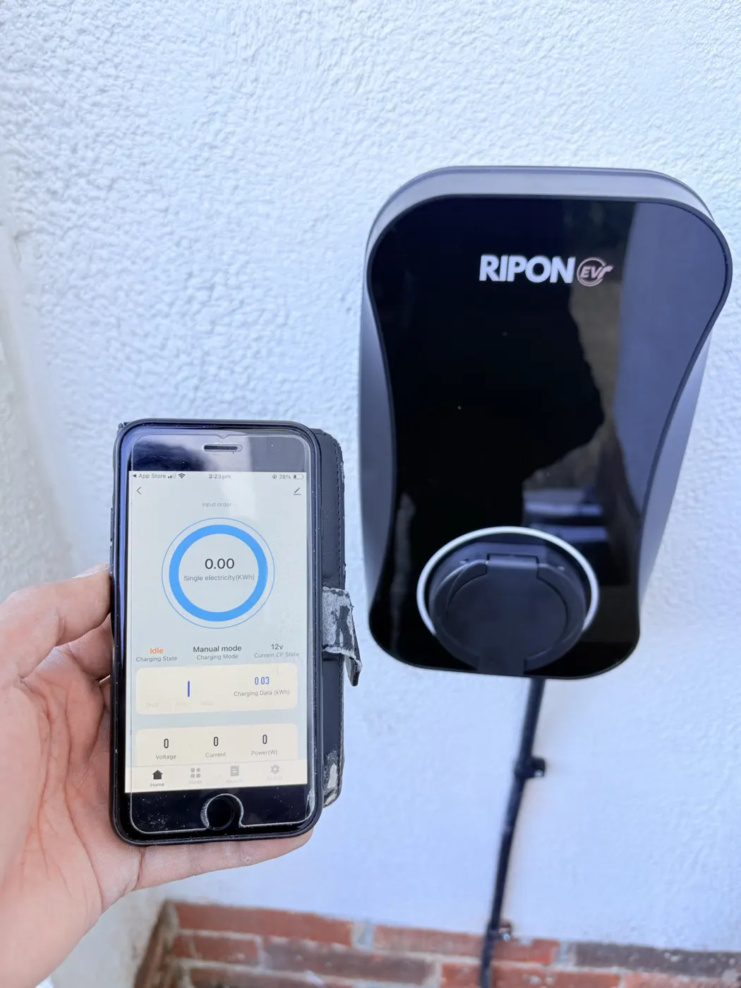 Phone showing the charger app next to a RiponEV charger