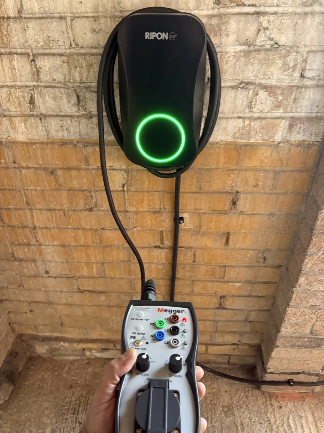 Electrician testing a RiponEV charger with a Megger EV test adaptor