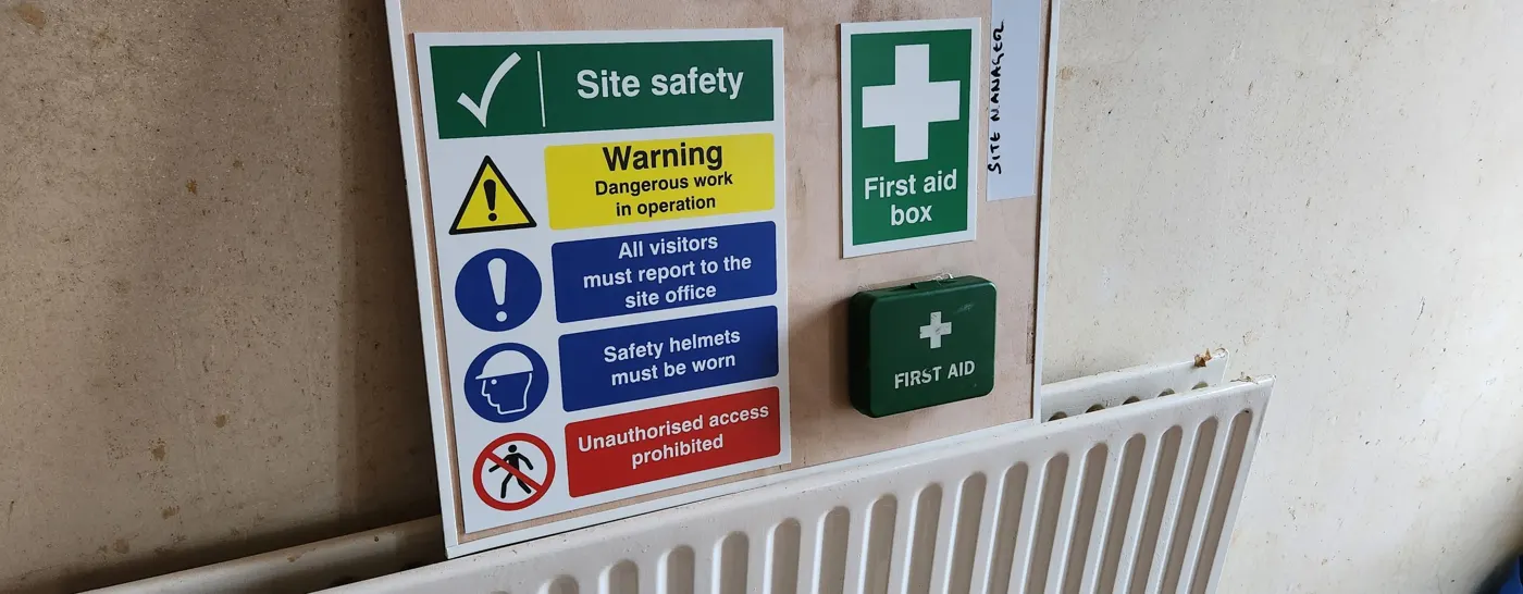 Site safety signage board with first aid kit
