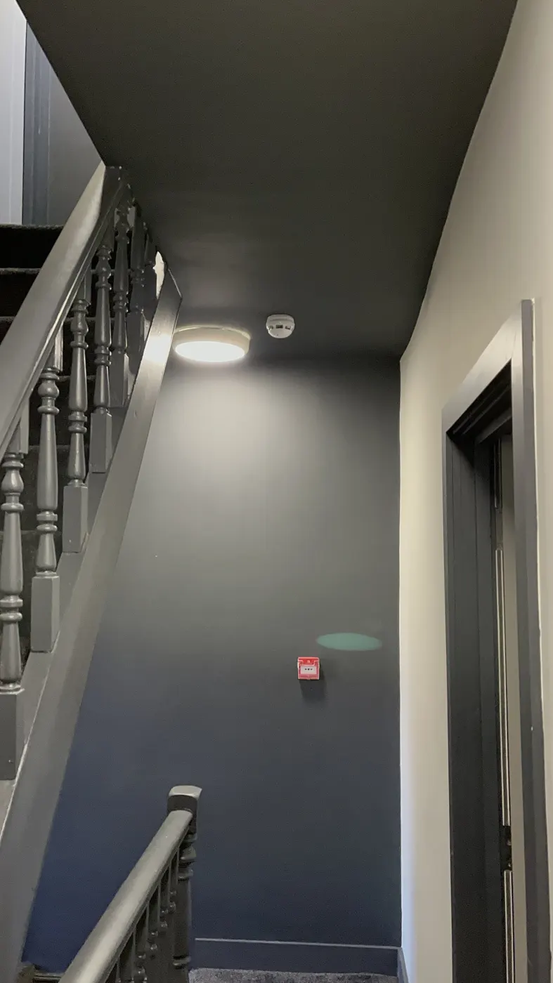 Stairwell with light fitting, smoke detector and manual call point