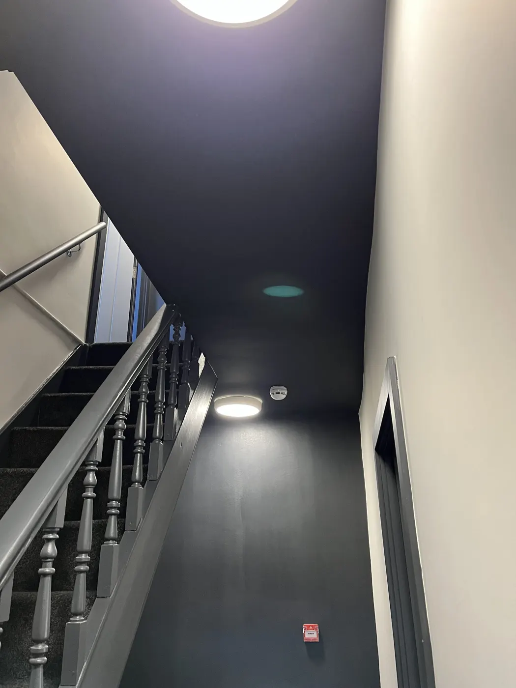 Communal stairwell with ceiling light, smoke detector and call point